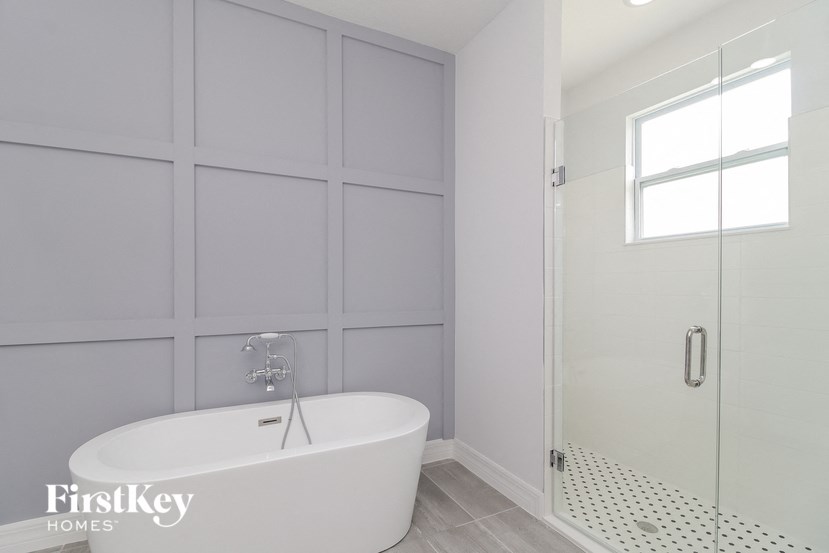 a white bathroom with a tub and a shower