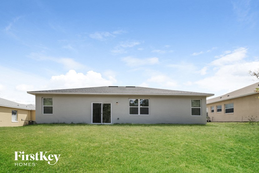 a small white house with a grass yard in front of it