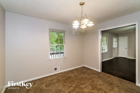 the living room and dining room of a house with carpeted flooring and a