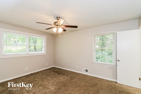 a bedroom with carpet and a ceiling fan