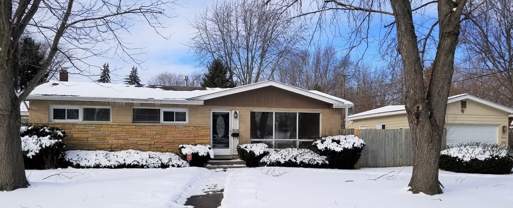 a brown house with snow on the ground