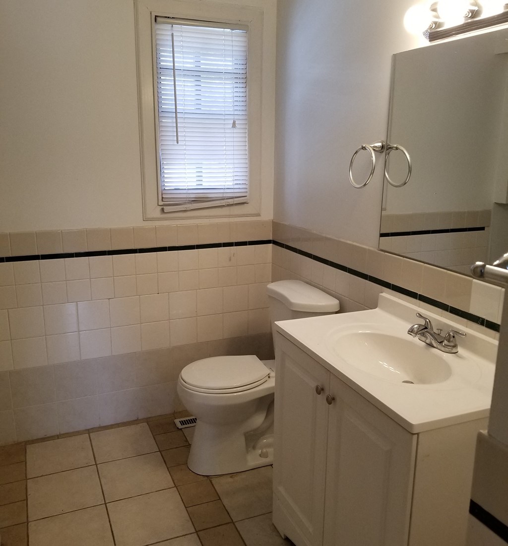 a bathroom with a toilet and a sink and a window
