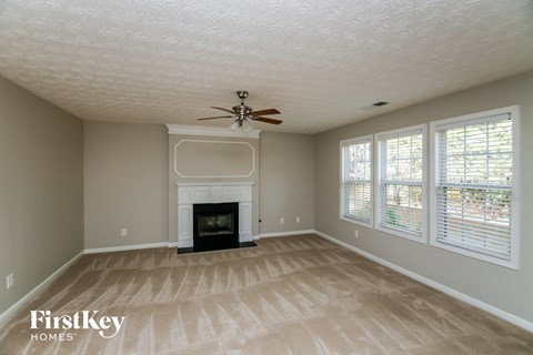 a living room with a fireplace and a ceiling fan