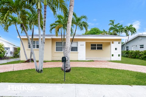 A house with a white fence and a mailbox in front of it.