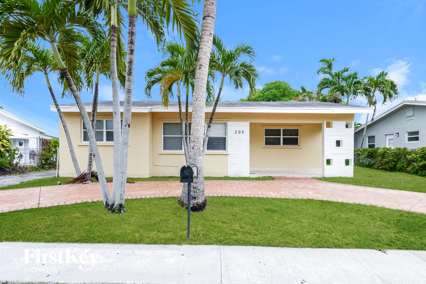 A house with a white fence and a mailbox in front of it.