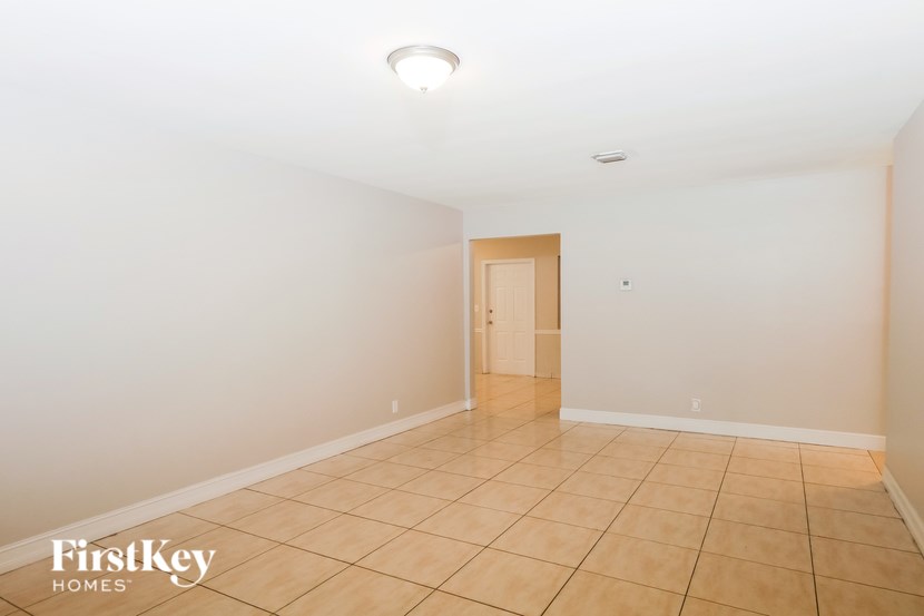 A room with a light brown tile floor and a wooden door.