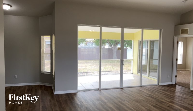 A room with a sliding glass door leading to a backyard.