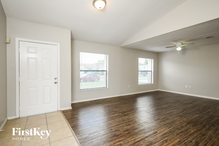 an empty living room with wood flooring and a white door