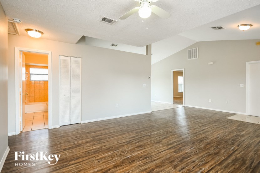 the living room and dining room of an empty house with wood flooring