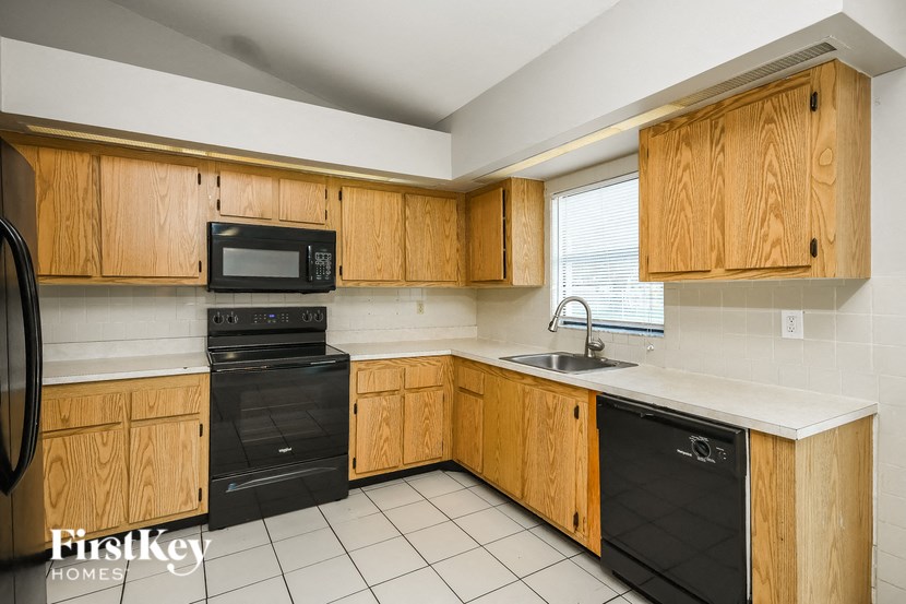 a kitchen with black appliances and wooden cabinets