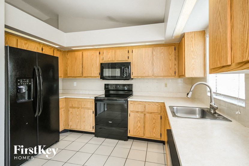a kitchen with black appliances and wooden cabinets
