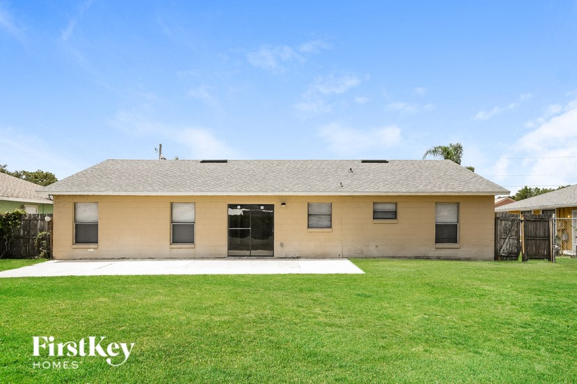 a small yellow house with a yard in front of it