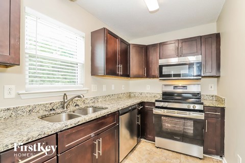 A kitchen with brown cabinets and a stainless steel oven.