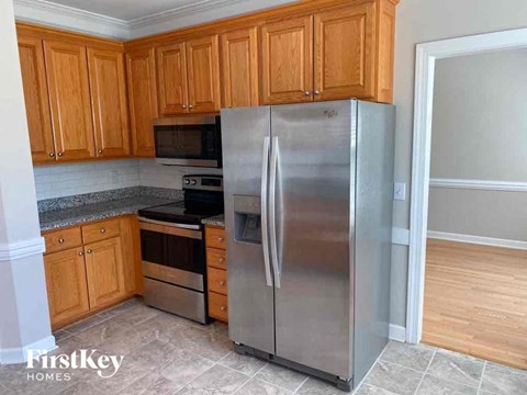 A kitchen with wooden cabinets and a stainless steel refrigerator.