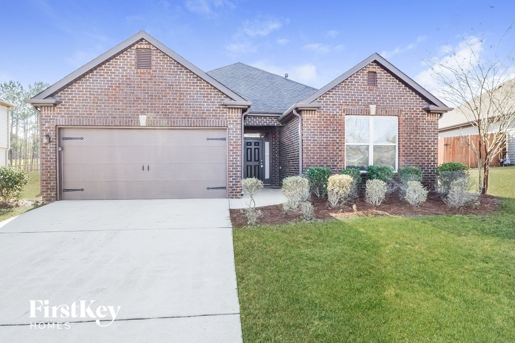 a brick house with a driveway and a garage door