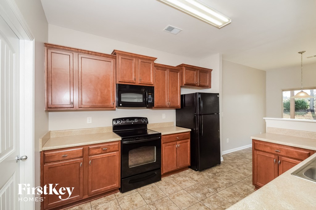a kitchen with wooden cabinets and black appliances