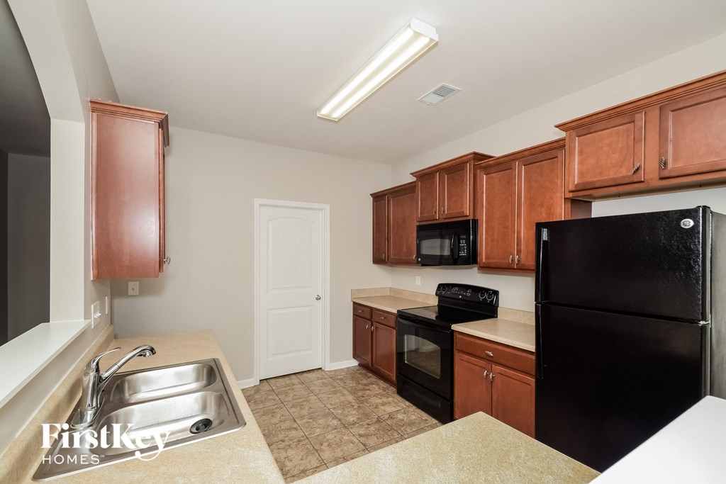 a kitchen with black appliances and brown cabinets