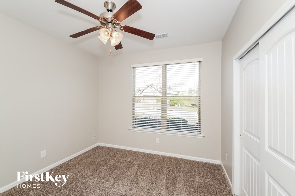 a bedroom with a ceiling fan and a window