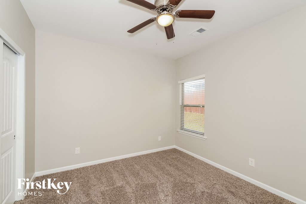 the living room has a ceiling fan and carpet