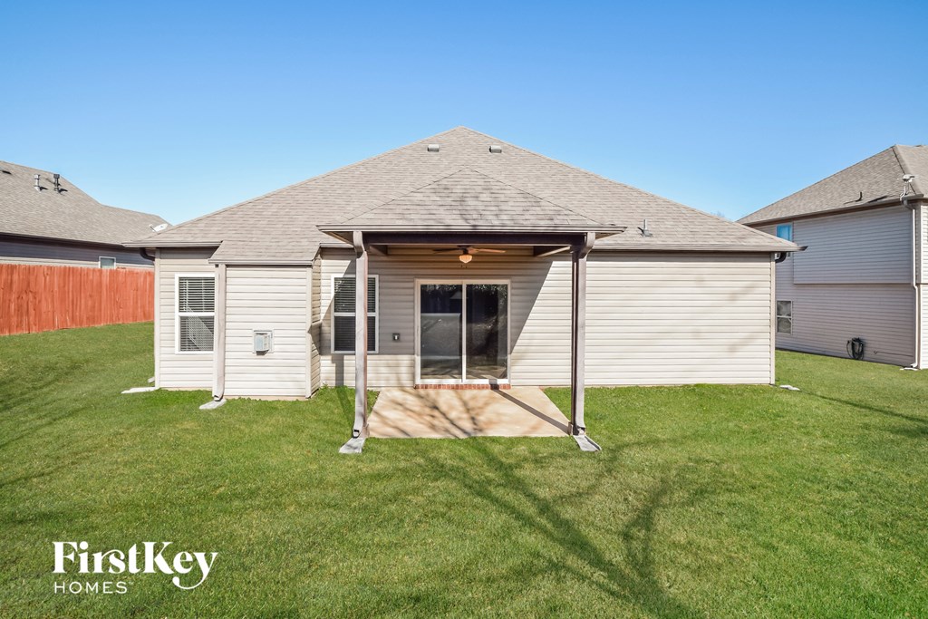 a small white house with a porch and a grassy yard