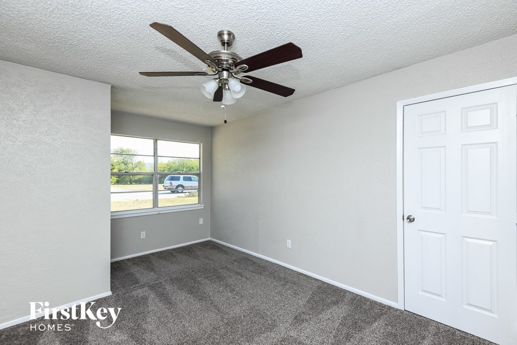 the living room of an empty house with a ceiling fan
