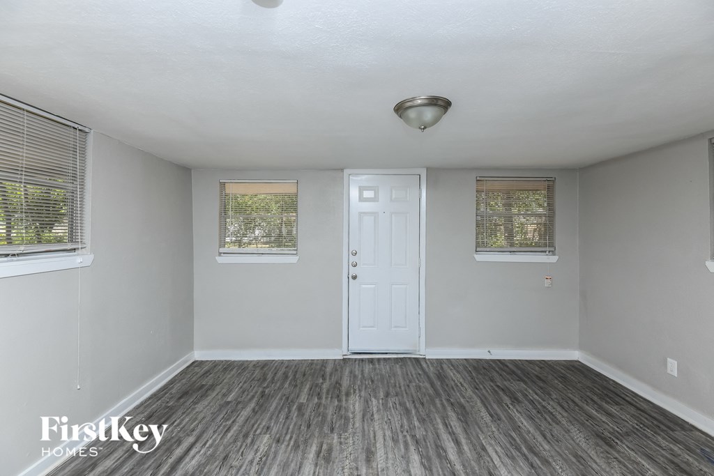 the living room of an empty house with a white door