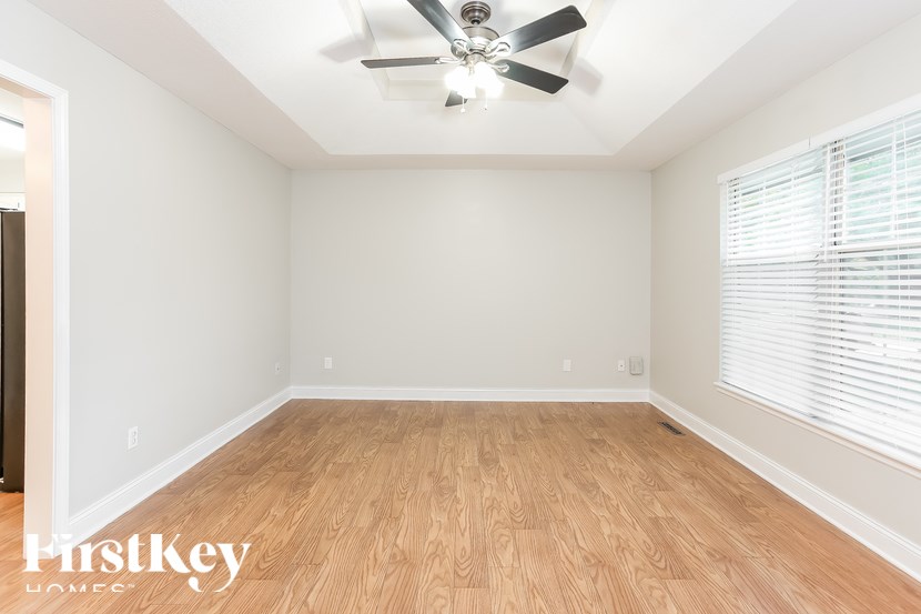 A room with a ceiling fan and wooden flooring.