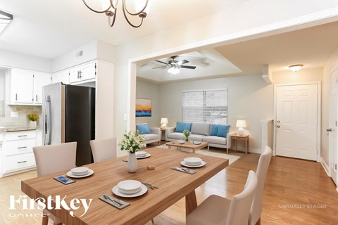 A dining room with a wooden table set for two.