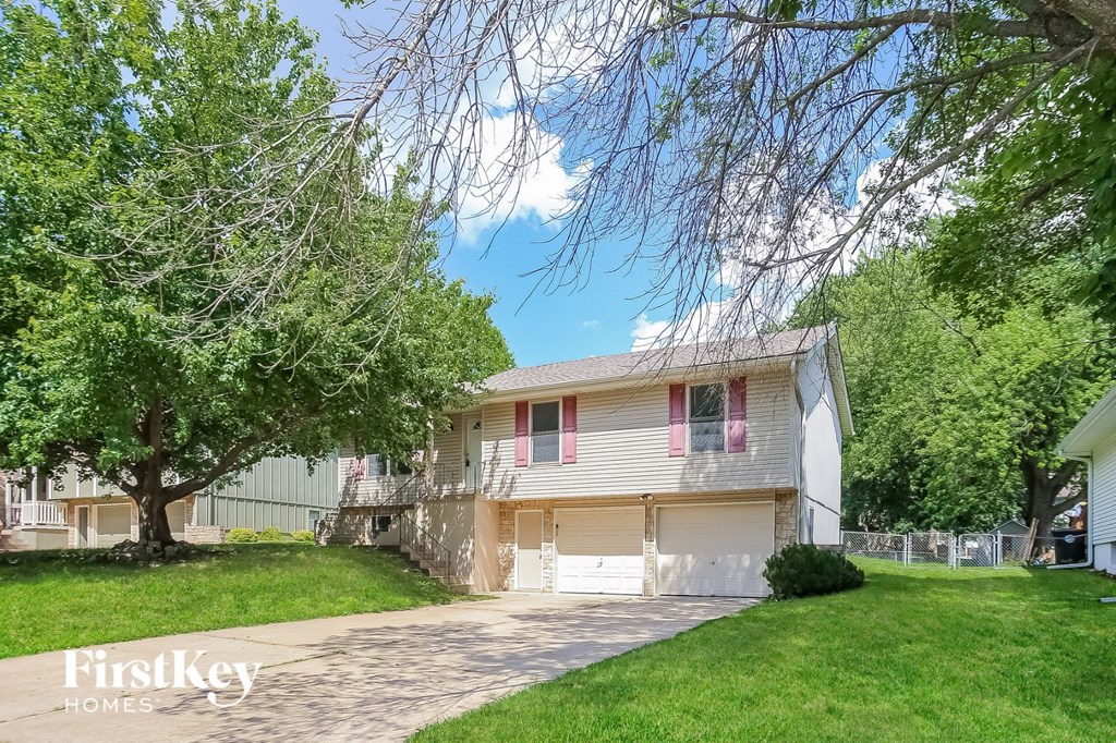 a white house with red shuttered windows and a sidewalk