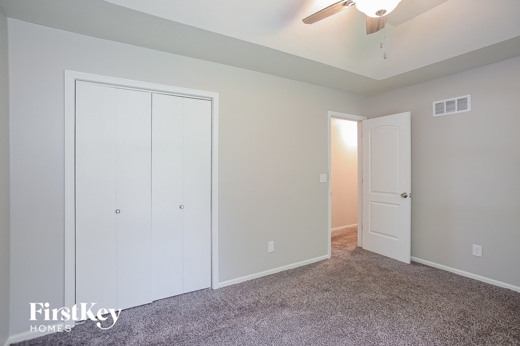 a bedroom with two closets and a ceiling fan