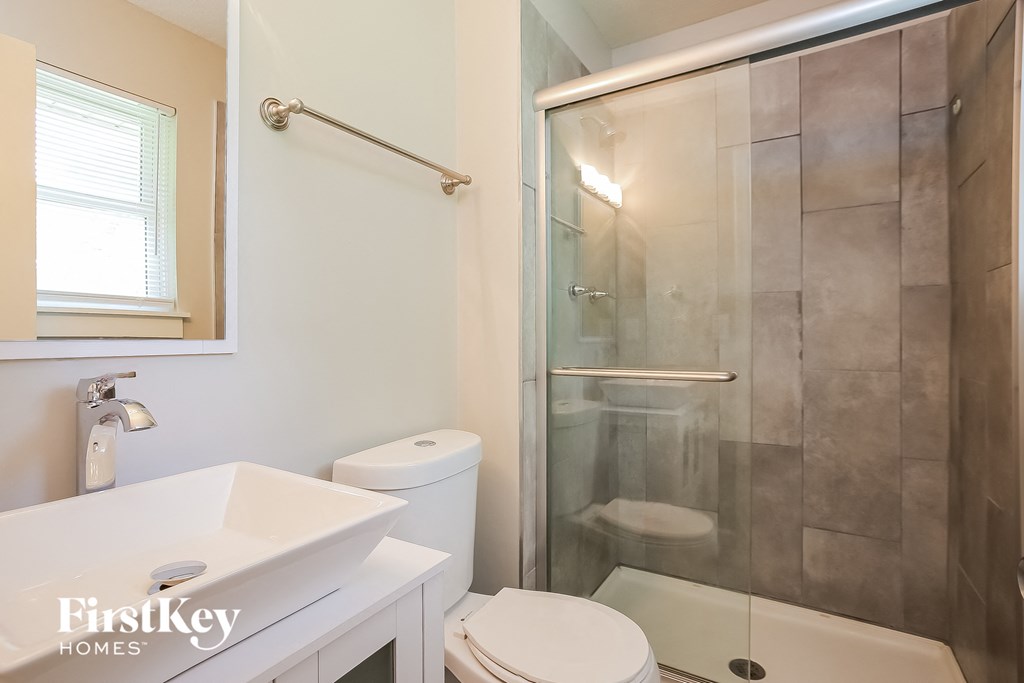 a bathroom with a shower and a sink and a toilet