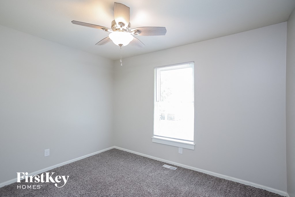 a bedroom with a ceiling fan and a window