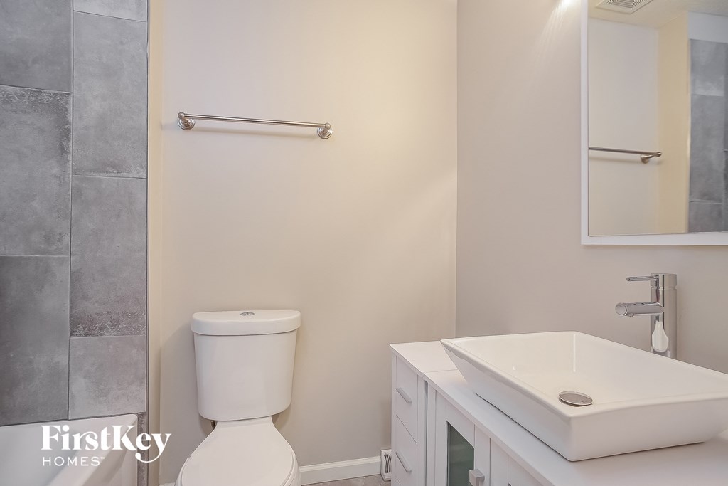 a bathroom with a toilet and a sink and a mirror