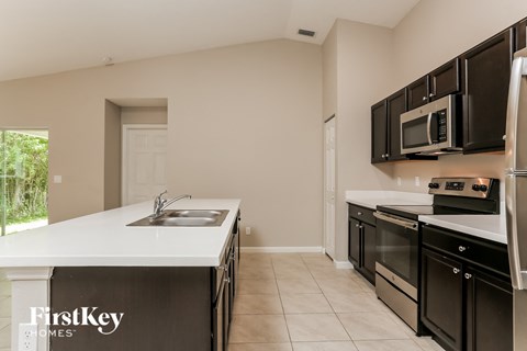 a kitchen with black cabinets and white counter tops and a sink