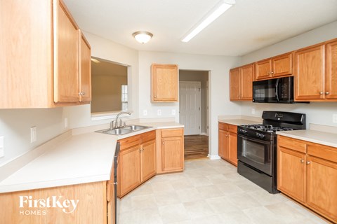 A kitchen with wooden cabinets and a black stove top oven.