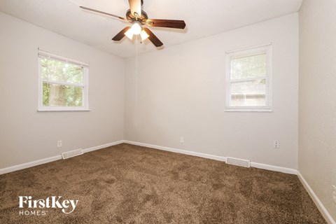 a bedroom with carpet and a ceiling fan
