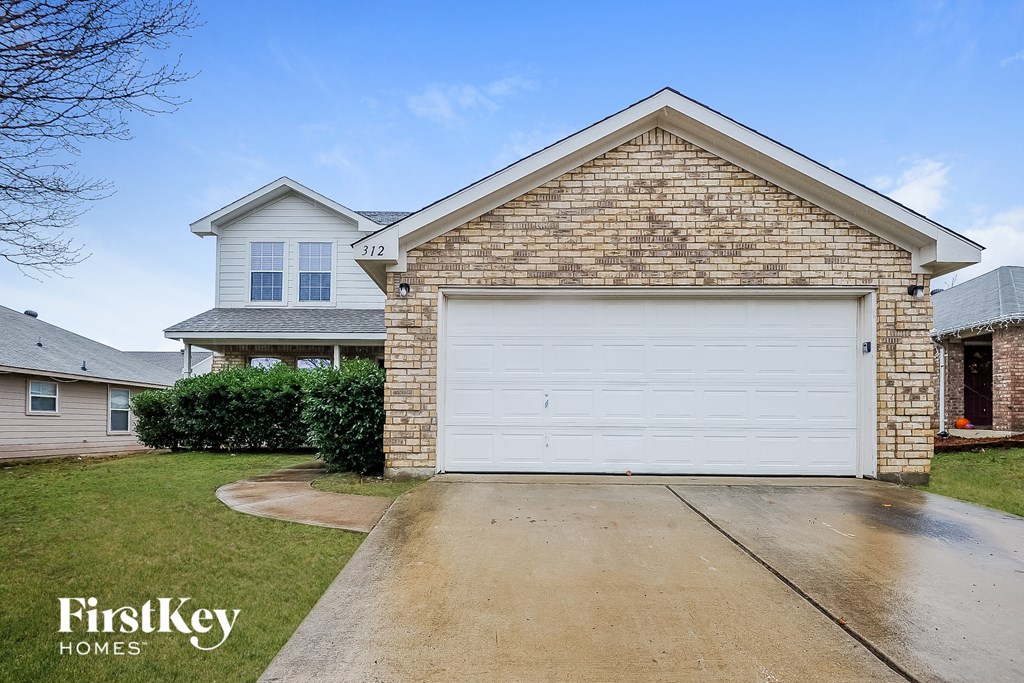 a white garage door in front of a brick house