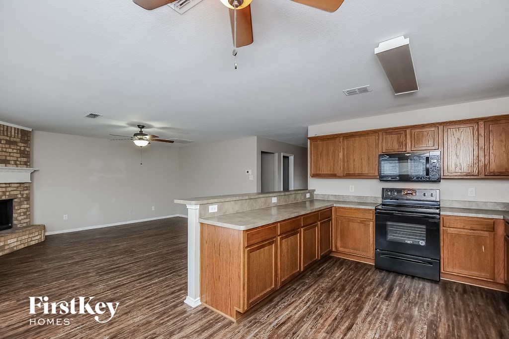 a kitchen with an island and a stove and a ceiling fan
