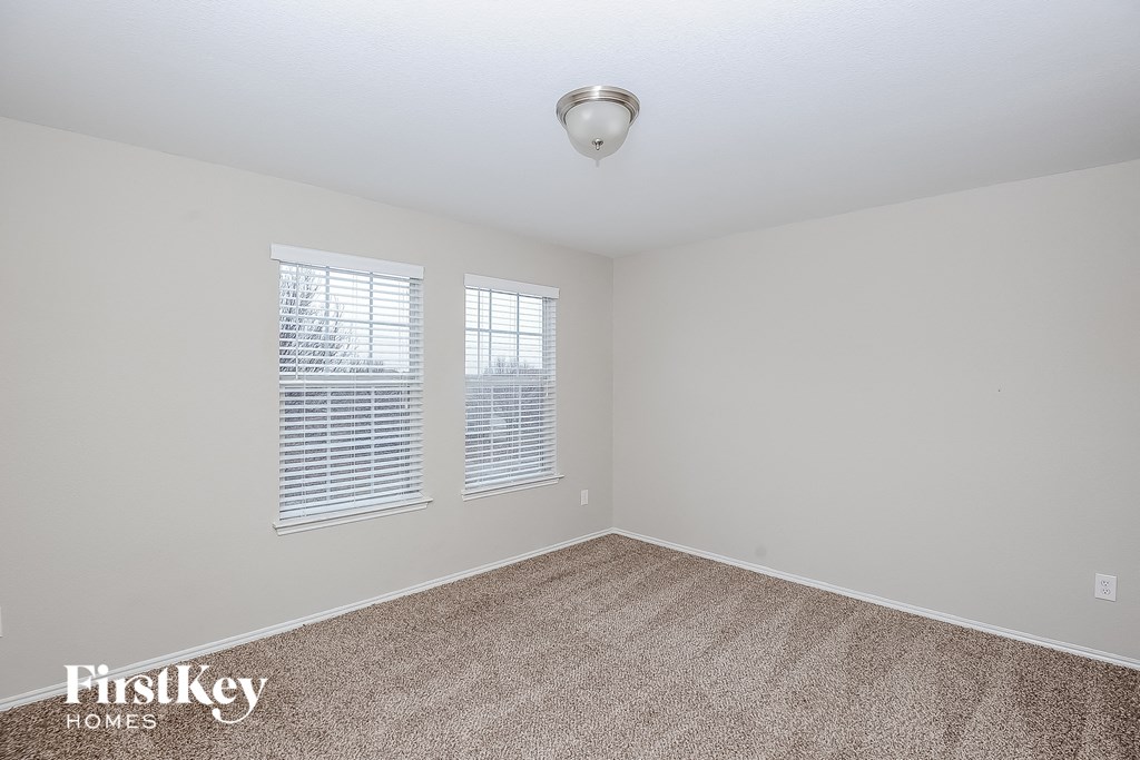 a bedroom with a carpeted floor and two windows