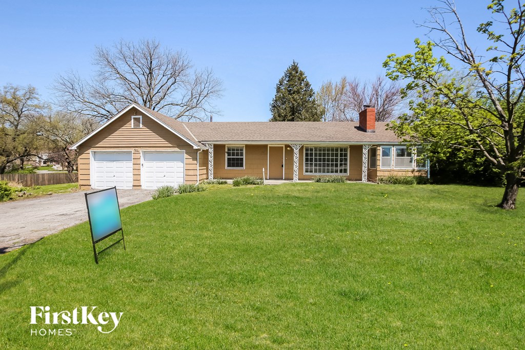 a house with a lawn and a sign in front of it