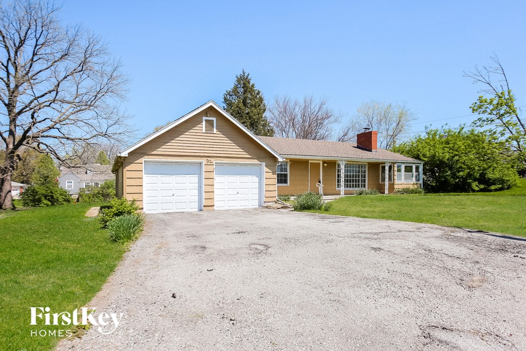 a house with a white garage door on a gravel driveway