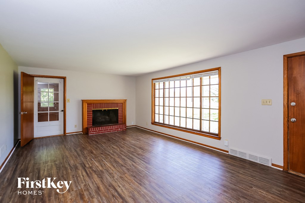 an empty living room with wood floors and a fireplace