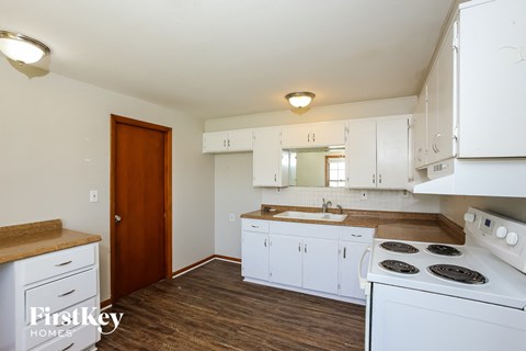 a kitchen with white cabinets and a stove and a sink