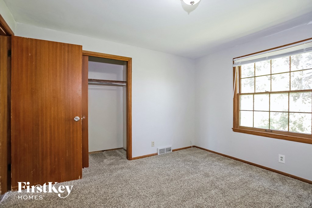 a bedroom with a closet and a door and a window