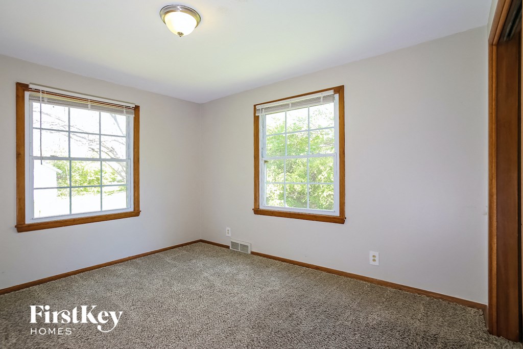 the master bedroom has a carpeted floor and two windows