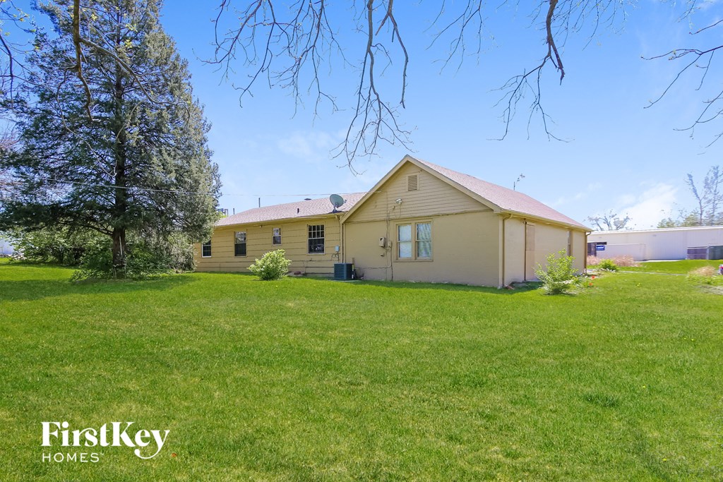 a house with a green lawn and a tree