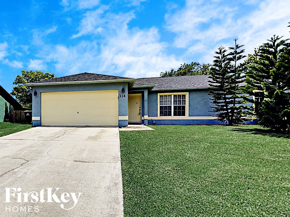 a blue house with a yard and a yellow garage door