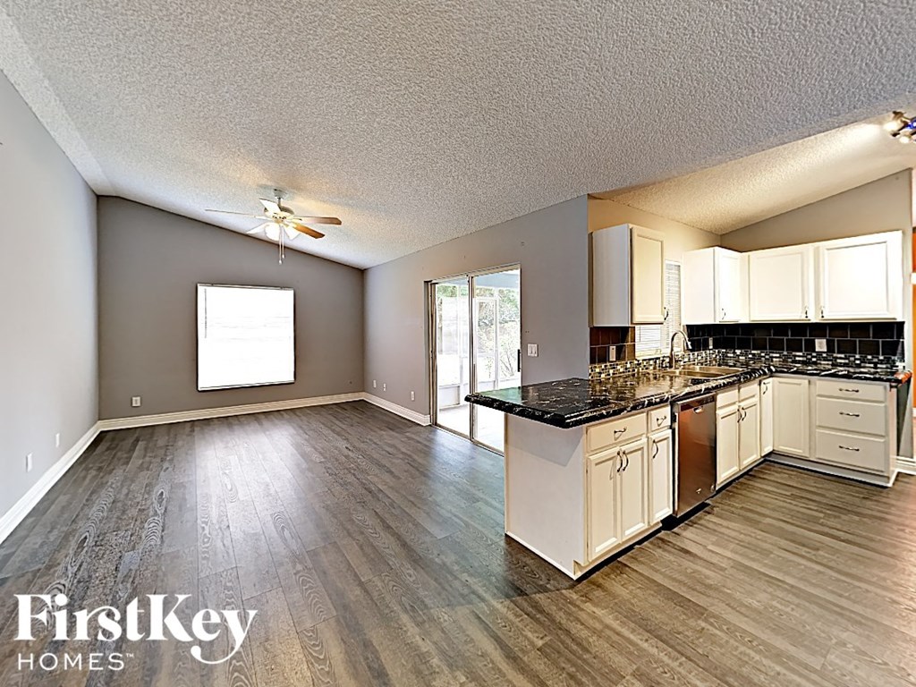 an empty kitchen and living room with a counter top