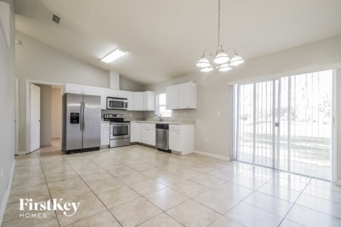 A spacious kitchen with white appliances and cabinets.