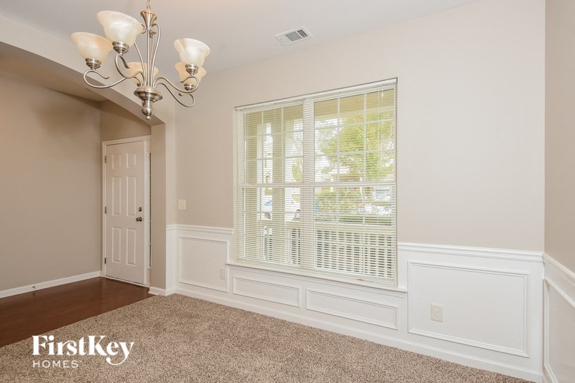 a dining room with a large window and a white door